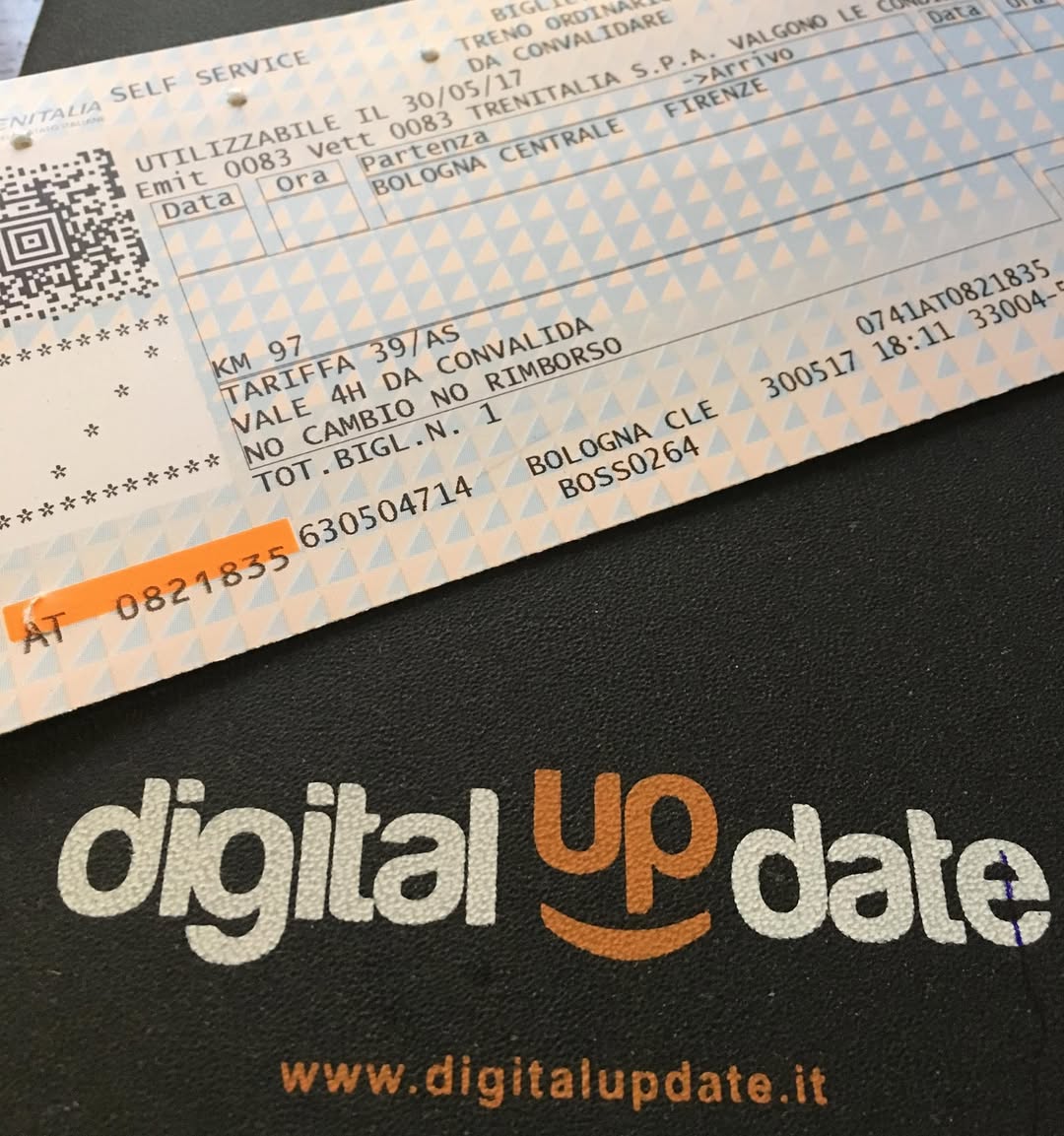 Biglietto del treno da Bologna a Firenze, su sfondo di un taccuino con il logo 'digital update'.
